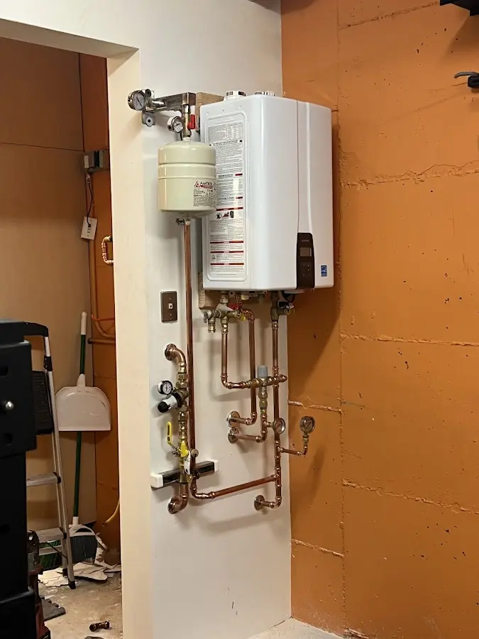 Plumbing technician inspecting water heater connections in Elmwood Park